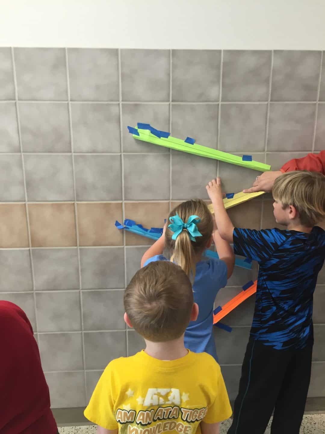 Image of children making a paper roller coaster - discovery lab