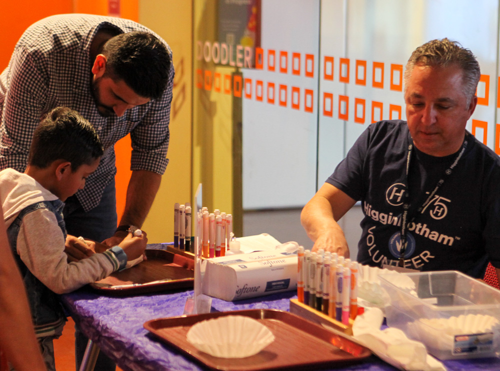 Higgenbotham volunteer interacts with a young musuem guest during an activity.