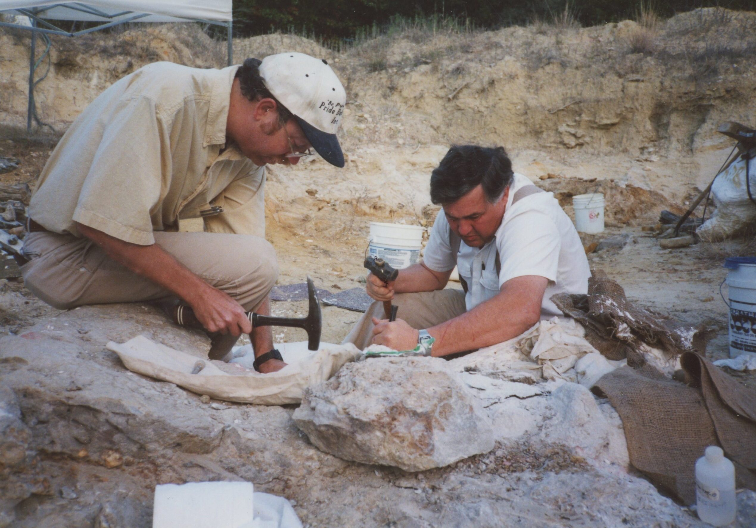 Dr. Dale Winkler, SMU. Jim Diffily, FWMSH. Working on removing a block that has parts of a foot, etc. Dinosaur Dig at Jones Ranch. 11-17-99
